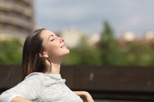 Photo of woman basking in the sun as a way to cope with parent sleep deprivation