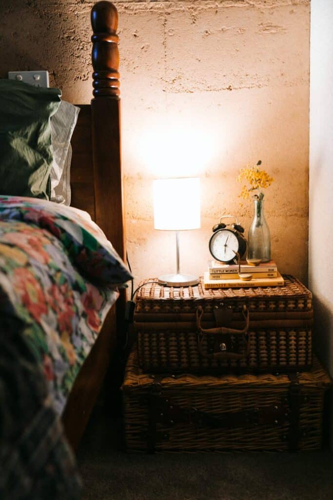 An example of a health sleep environment with a dim lamp and books on the nightstand.